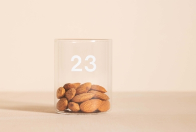  A small glass container labeled "23" partially filled with almonds, highlighting a portion-controlled snack for blood sugar management.